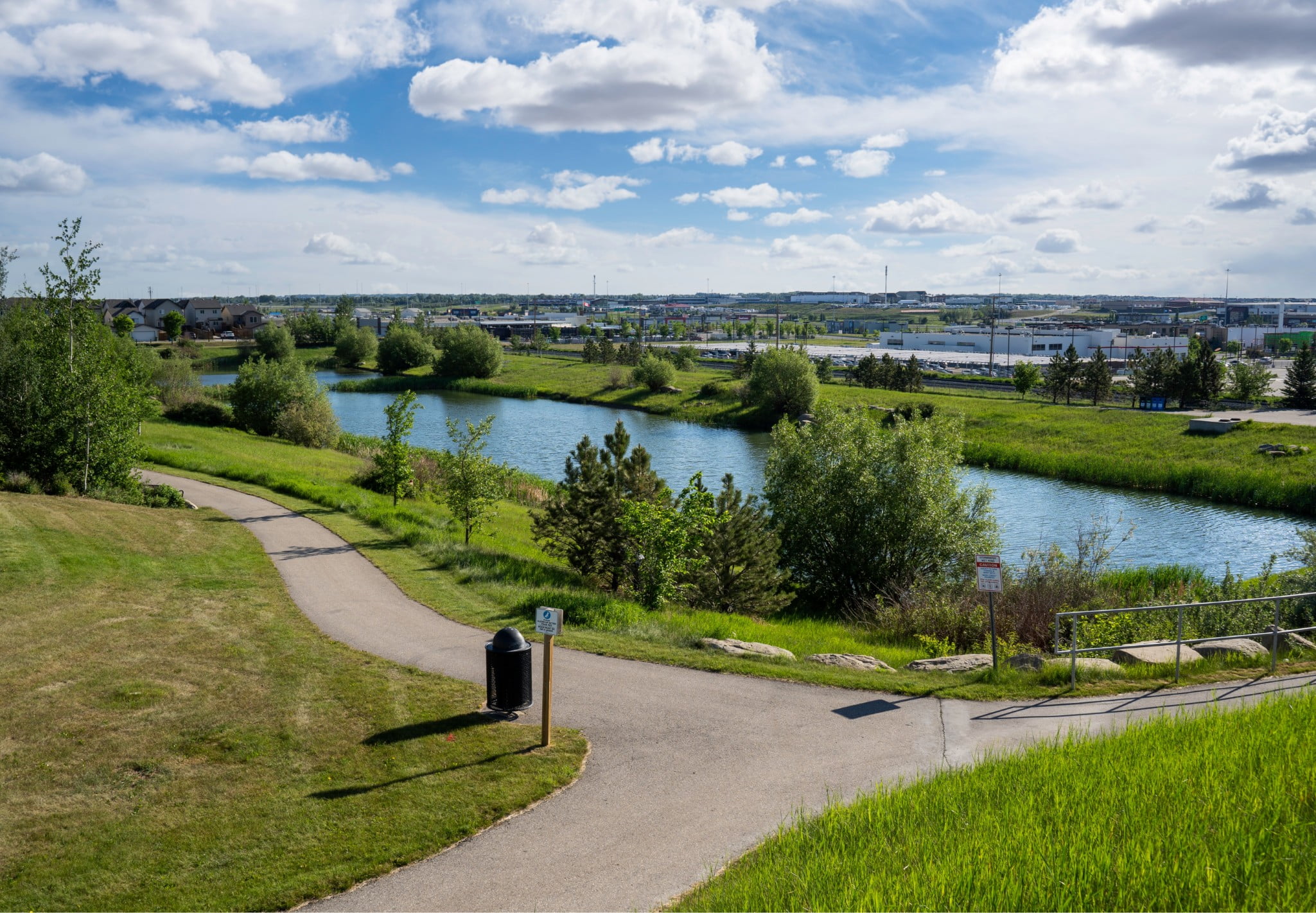 A picture of a park with a pond and pathways